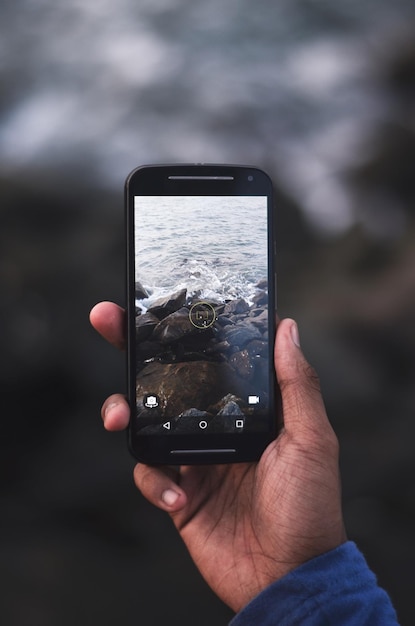 Mittelabschnitt einer Person, die mit einem Handy fotografiert