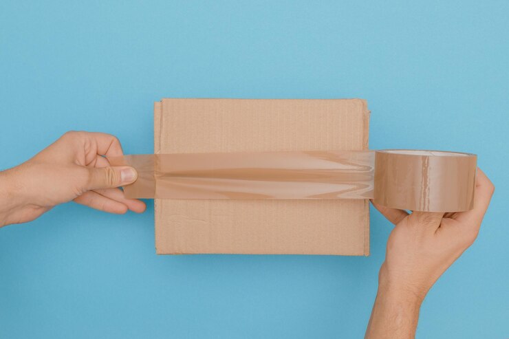 Foto mittelabschnitt einer person, die papier vor blauem hintergrund hält