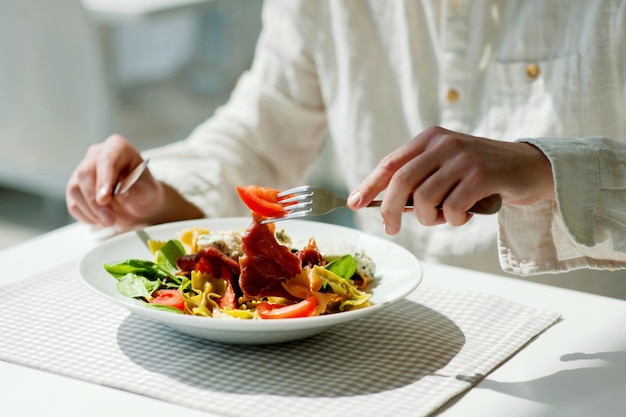 Mittelabschnitt einer Person, die Pasta in einem Restaurant hält