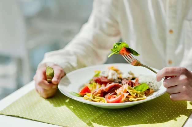 Mittelabschnitt einer Person, die Pasta in einem Restaurant hält