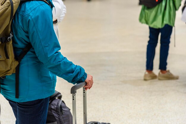 Foto mittelabschnitt einer person mit auf der straße stehendem gepäck