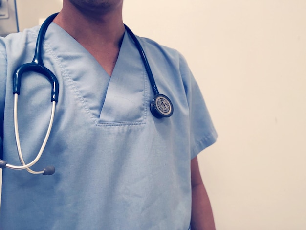 Mittelabschnitt einer Person mit Hut, die vor weißem Hintergrund steht