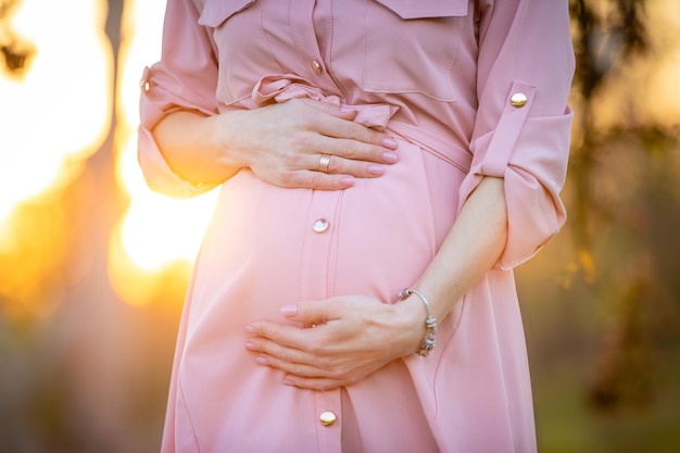 Mittelabschnitt einer schwangeren Frau berührt den Bauch