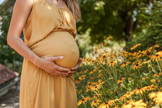 Foto mittelabschnitt einer schwangeren frau, die im freien stehen und den magen hält