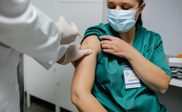 Mittelabschnitt eines Arztes, der einen Patienten in einer Klinik impft