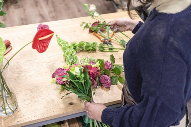 Foto mittelabschnitt eines blumenhändlers, der eine blume im laden hält