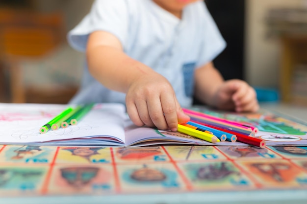 Mittelabschnitt eines Jungen, der zu Hause auf dem Tisch zeichnet