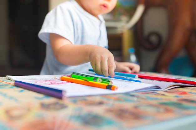 Mittelabschnitt eines Jungen, der zu Hause auf dem Tisch zeichnet