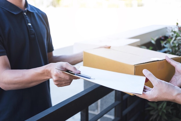 Foto mittelabschnitt eines mannes, der ein paket an einen männlichen kunden am tor liefert