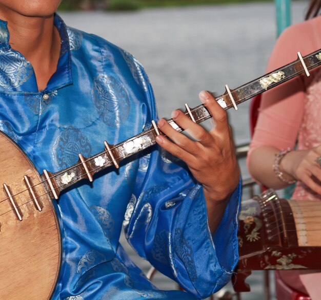 Foto mittelabschnitt eines mannes, der ein saiteninstrument spielt