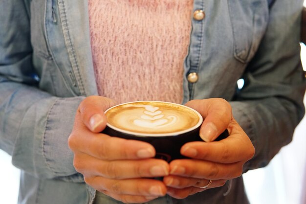 Foto mittelabschnitt eines mannes, der eine kaffeetasse hält