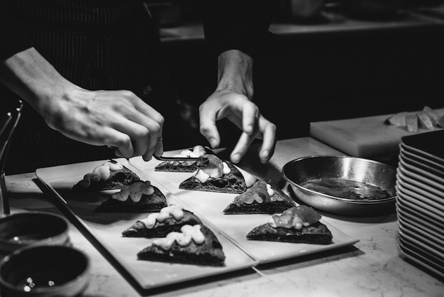 Foto mittelabschnitt eines mannes, der essen auf dem tisch garniert