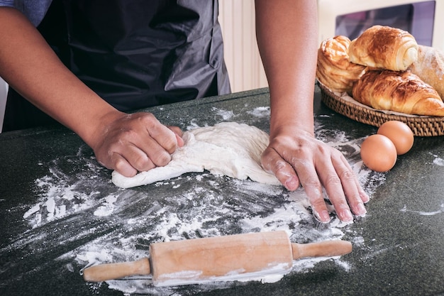 Foto mittelabschnitt eines mannes, der essen auf dem tisch zubereitet