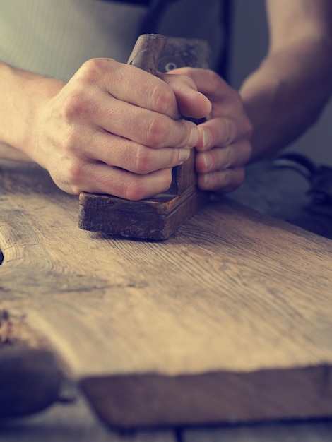 Mittelabschnitt eines Mannes, der in einer Werkstatt an Holz arbeitet