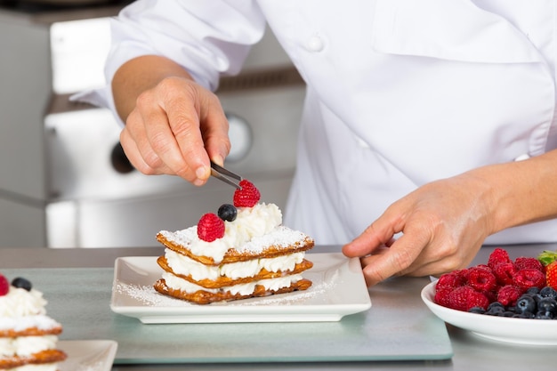 Foto mittelabschnitt eines mannes, der kuchen auf einem teller zubereitet