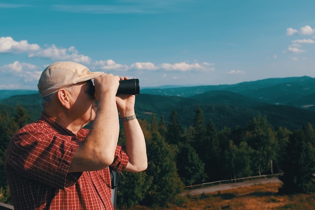 Foto mittelabschnitt eines mannes, der mit dem handy gegen berge fotografiert