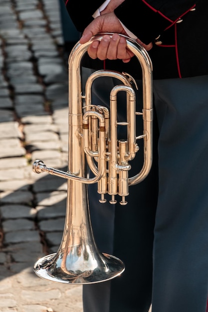 Foto mittelabschnitt eines mannes mit blasinstrument, der an einem sonnigen tag auf einem fußweg steht