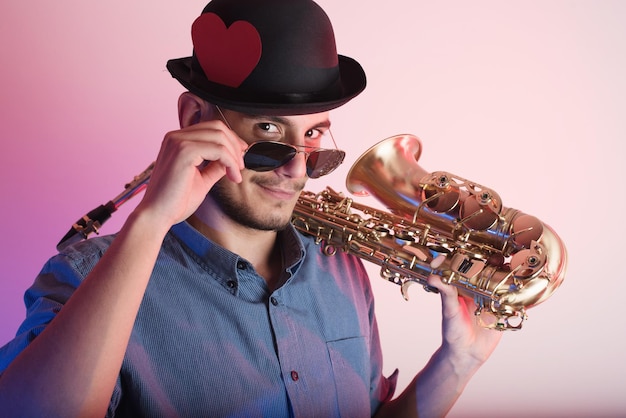 Mittelabschnitt eines Mannes mit Hut, der ein Saxophon hält