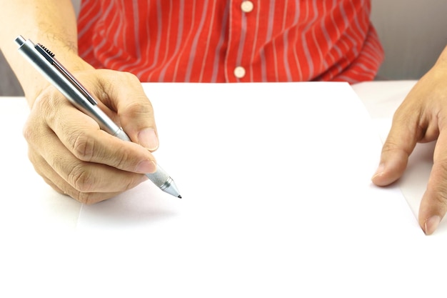 Foto mittelabschnitt eines mannes mit stift und papier auf dem tisch