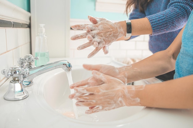 Mittelabschnitt von Frauen, die sich die Hände im Waschbecken waschen