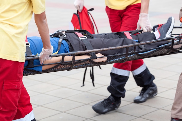Foto mittelabschnitt von männern, die einen patienten auf einer trage tragen