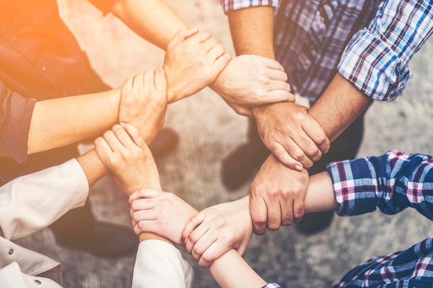 Foto mittelabschnitt von menschen, die sich die hände halten, während sie einheit zeigen