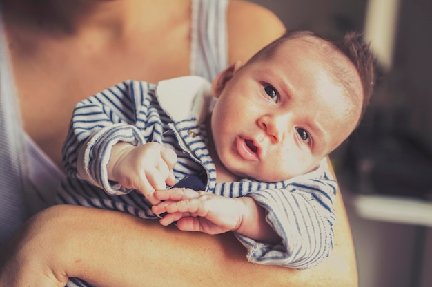 Mittelabschnitt von Mutter mit Baby zu Hause