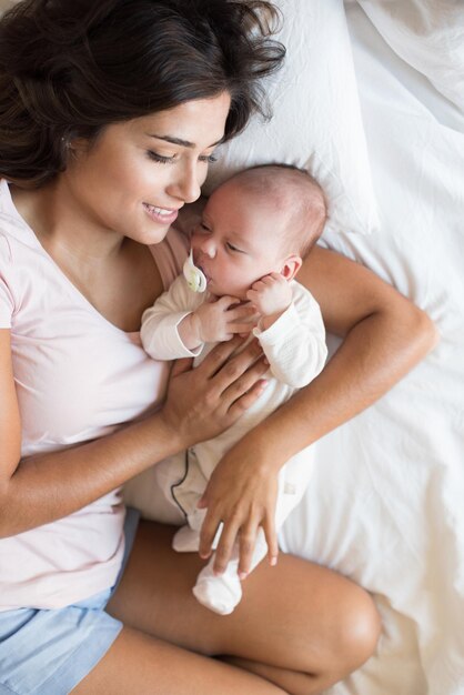 Foto mittelabschnitt von mutter und tochter baby auf dem bett