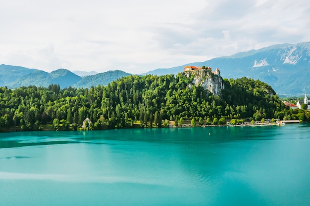 Mittelalterliche Burg von Bled auf der Klippe des Berges unter dem blutigen See mit türkisblauem Wasser in