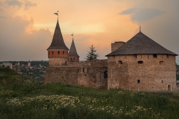 Mittelalterliche Festung bei Sonnenuntergang und Feld mit Blumen