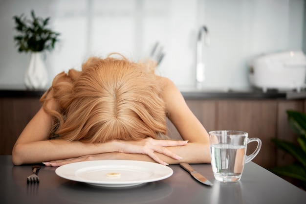 Foto mittelgroße kranke frau mit dem kopf auf dem tisch