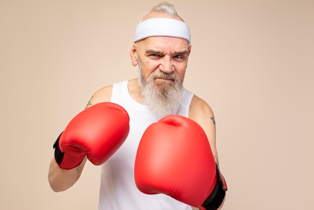 Mittelgroßer alter Mann mit Boxhandschuhen