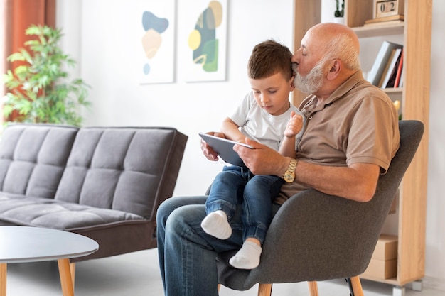 Foto mittelgroßer großvater mit kind und tablette