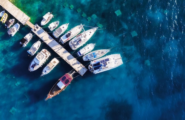 Mittelmeer Blick auf den Jachthafen von der Drohne Luftaufnahme des schwimmenden Bootes auf blauem Meer am sonnigen Tag Reise- und Entspannungsbild