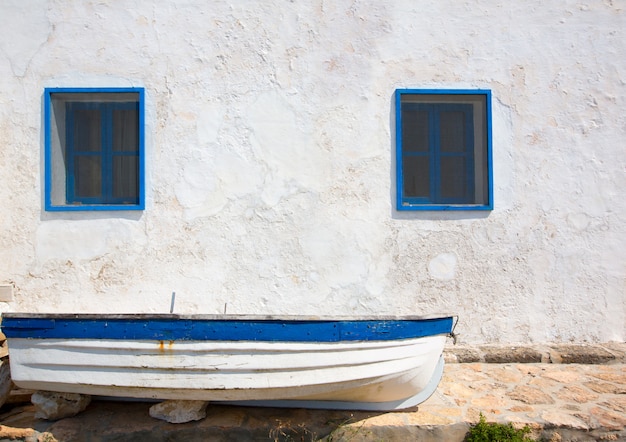 Mittelmeerboot und weiß getünchte Wand in Weiß und Blau