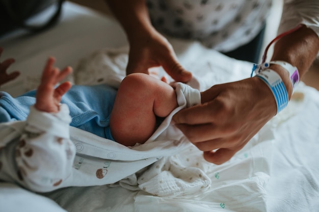 Foto mittelschnitt einer frau mit einem neugeborenen sohn, die im krankenhaus auf dem bett liegt