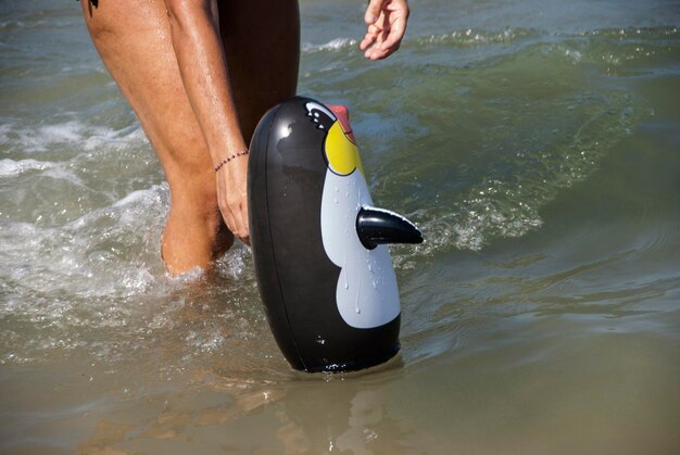 Foto mittelschnitt einer person mit aufblasbarem spielzeug im meer