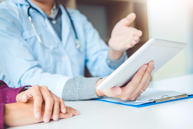 Foto mittelschnitt eines arztes, der einem patienten im krankenhaus ein digitales tablet zeigt