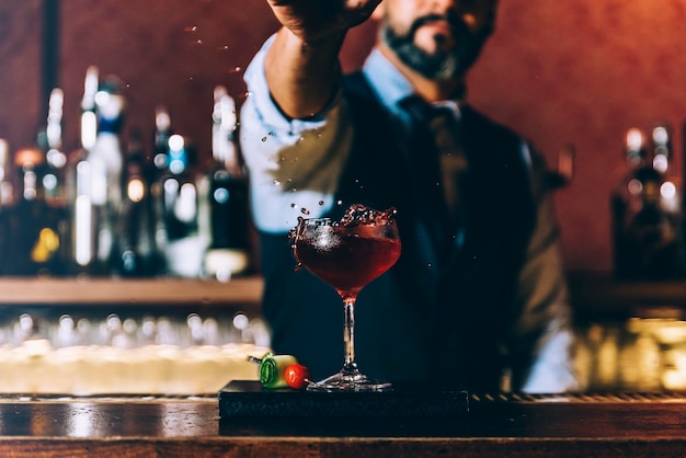 Mittelschnitt eines Barkeepers, der einen Cocktail in einer Bar zubereitet