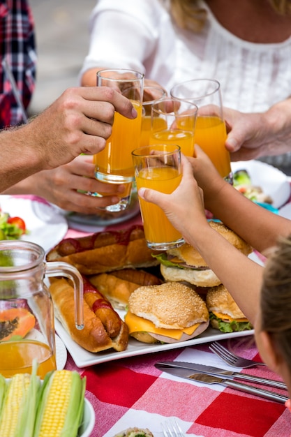 Mittelteil der Familie, die Getränke beim Mittagessen röstet