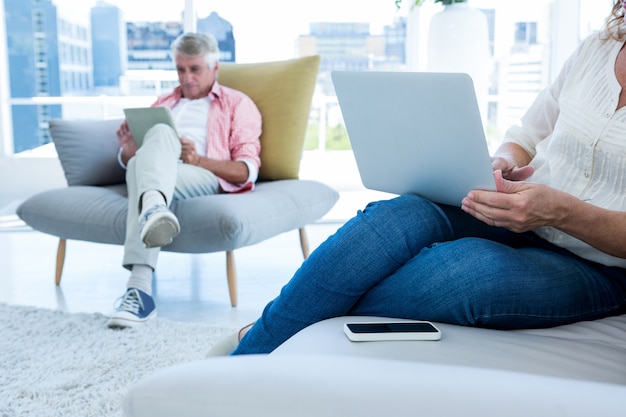 Mittelteil der Frau mit Notizbuch mit Mann zu Hause