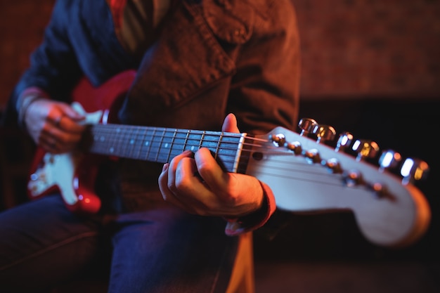 Mittelteil des Mannes, der Gitarre spielt