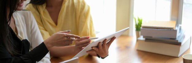 Foto mittelteil einer frau, die ein smartphone auf dem tisch hält