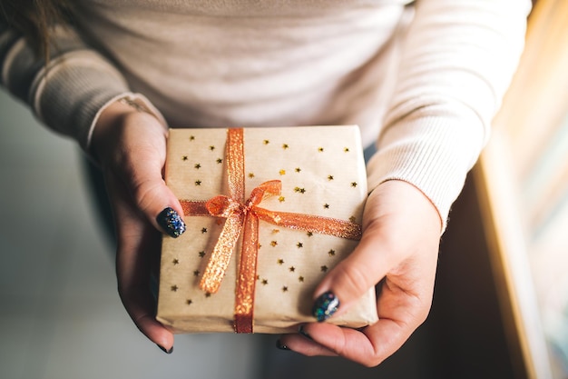 Mittelteil einer Frau, die ein Weihnachtsgeschenk hält