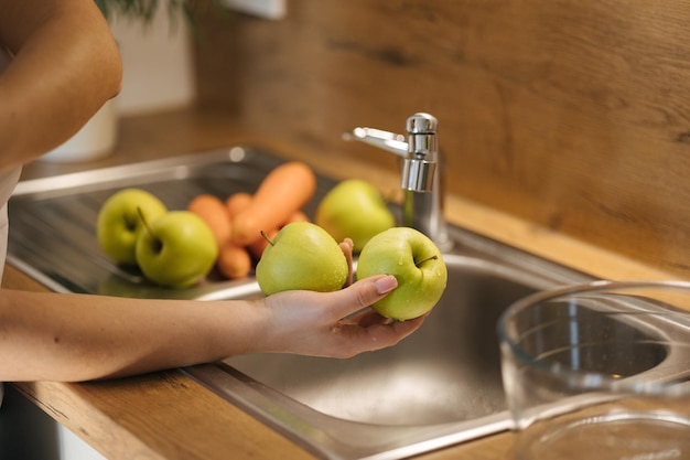 Mittelwahl von Frauen, die Äpfel waschen und Früchte für einen gesunden hausgemachten Saft zubereiten