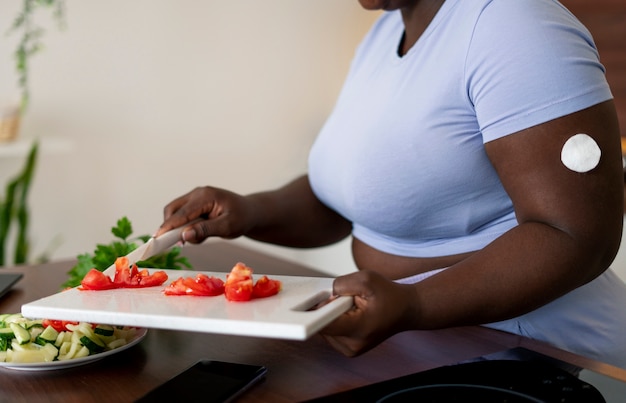 Foto mittlere aufnahme einer diabetikerin, die ihren glukosespiegel überprüft