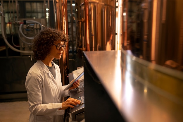 Foto mittlere aufnahme einer frau, die in einer bierfabrik arbeitet