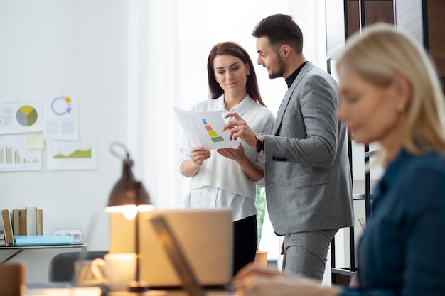 Foto mittlere aufnahme von leuten, die bei der arbeit diskutieren