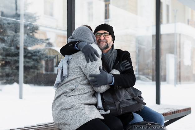 Foto mittlere aufnahme von menschen, die sich auf der bank umarmen