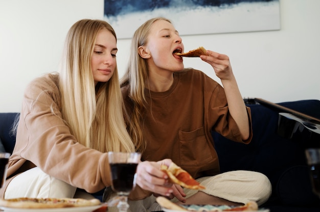 Mittlere Aufnahme von Mitbewohnern, die Pizza essen